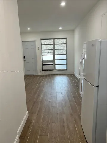 a view of a room with wooden floor and a window