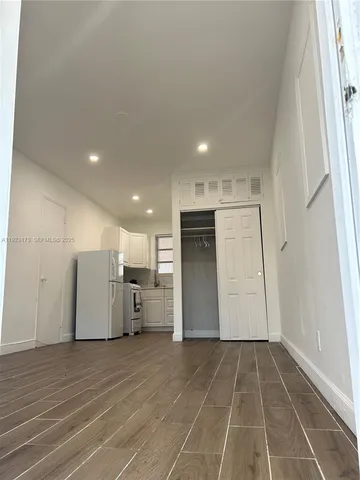 a view of a kitchen with furniture and refrigerator