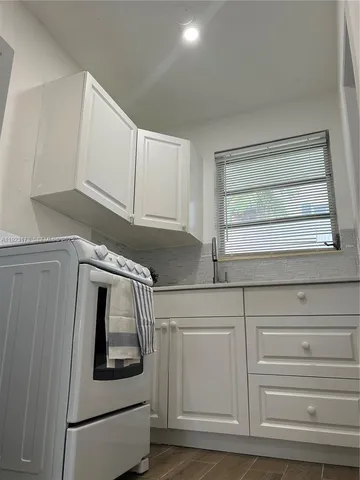 a kitchen with white cabinets and white appliances