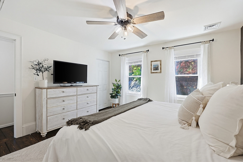 345 Sherman Street Canton, MA 02021 - Photo 20 of 42 a bedroom with a large bed a flat tv screen and chandelier