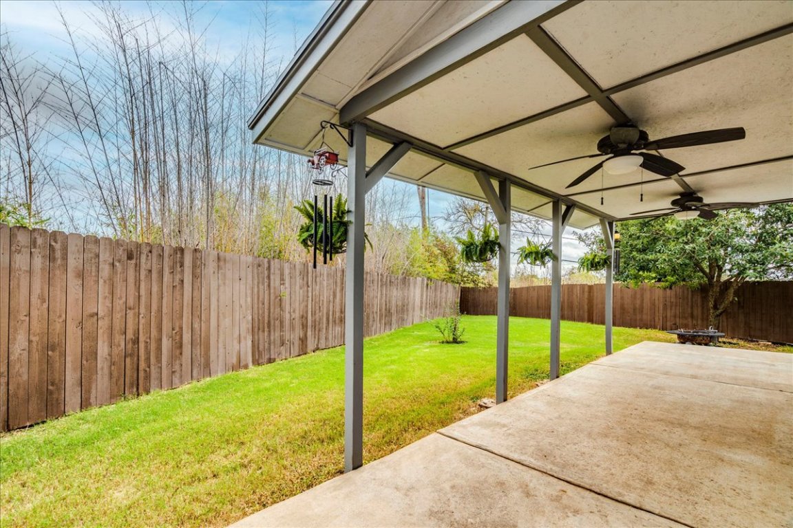 18436 Wind Tree Lane Elgin, TX 78621 - Photo 26 of 34 Fully fenced backyard featuring covered patio area with ceiling fan for comfortable outdoor entertaining