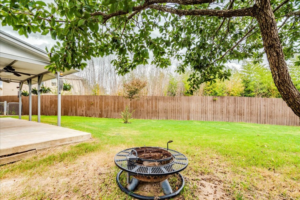 18436 Wind Tree Lane Elgin, TX 78621 - Photo 29 of 34 Fenced backyard with an outdoor fire pit