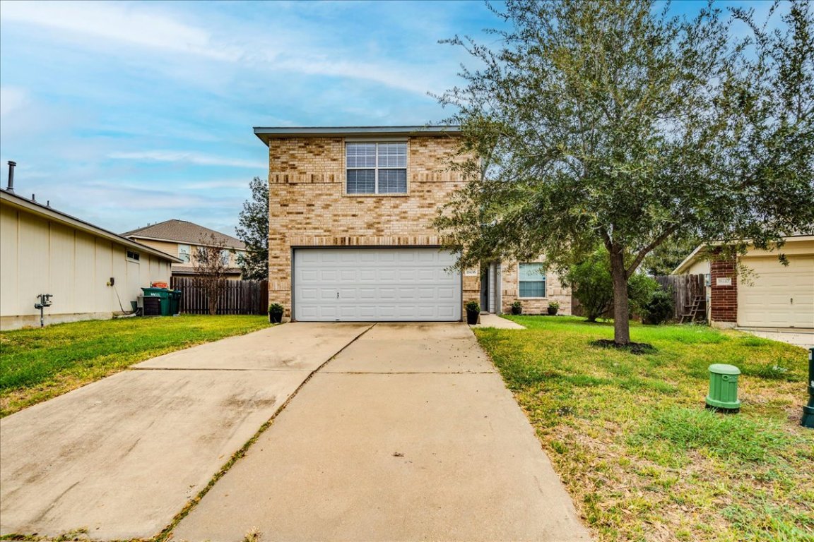 18436 Wind Tree Lane Elgin, TX 78621 - Photo 31 of 34 a front view of a house with a yard and garage