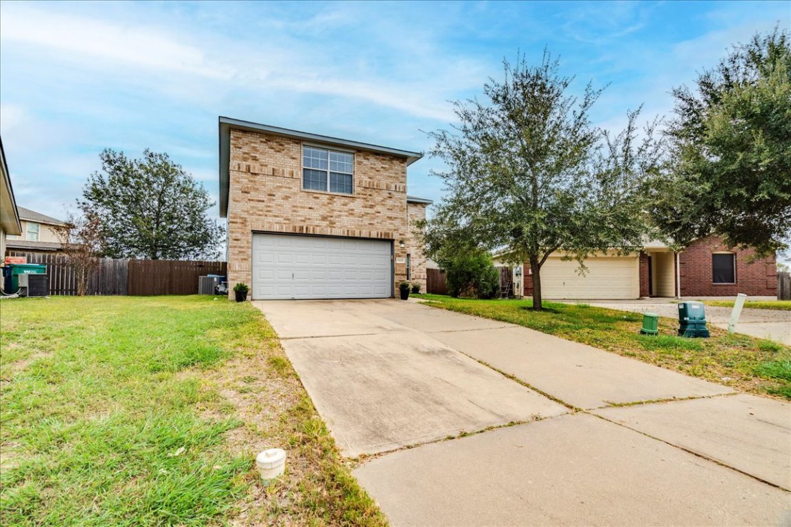 18436 Wind Tree Lane Elgin, TX 78621 - Photo 32 of 34 a front view of a house with a yard and a garage