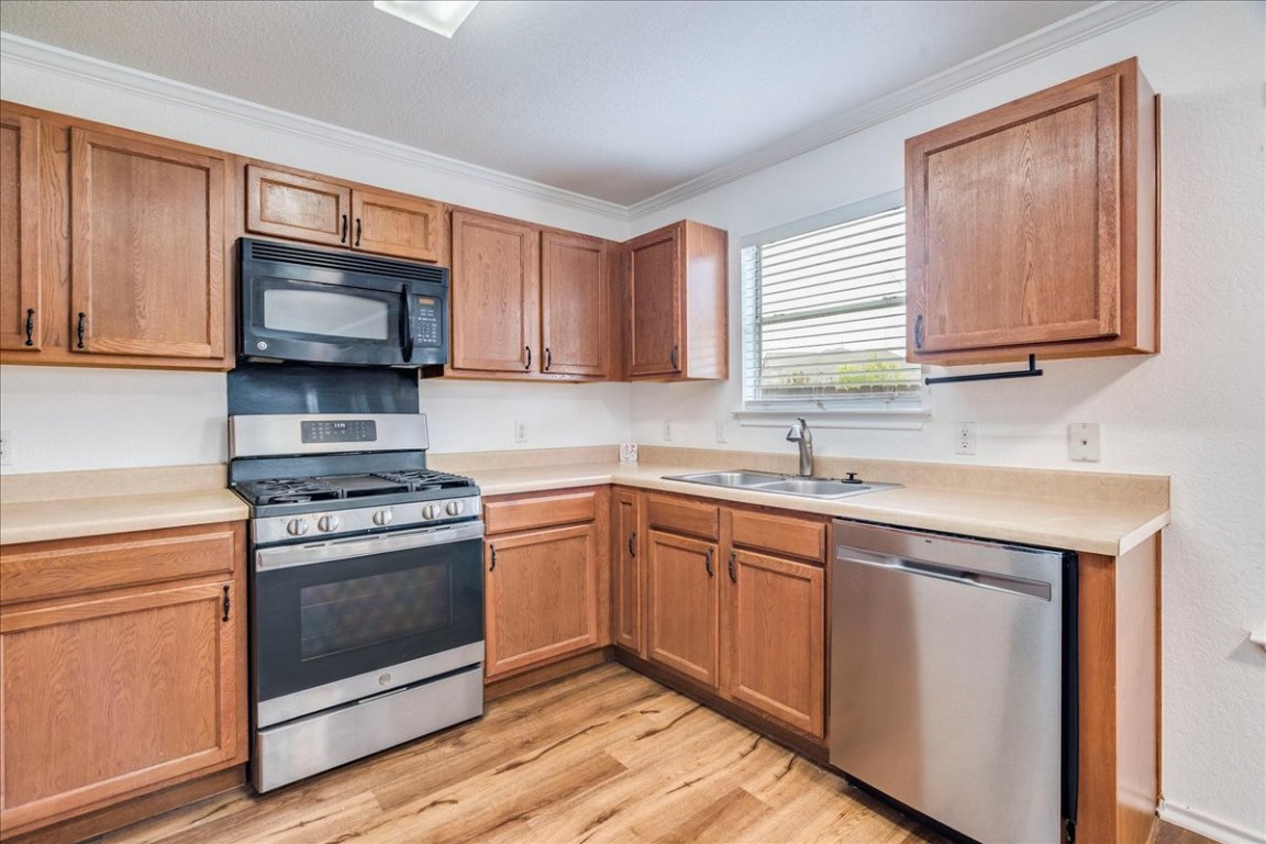 18436 Wind Tree Lane Elgin, TX 78621 - Photo 8 of 34 a kitchen with granite countertop cabinets stainless steel appliances and a sink