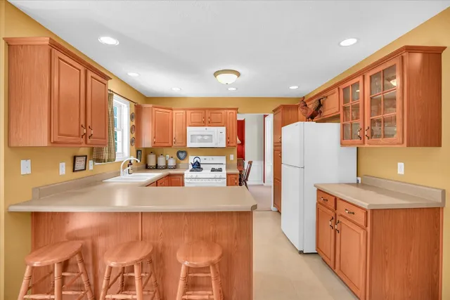 a kitchen with refrigerator a stove a sink and cabinets