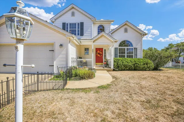 a view of a white house with large windows and a yard