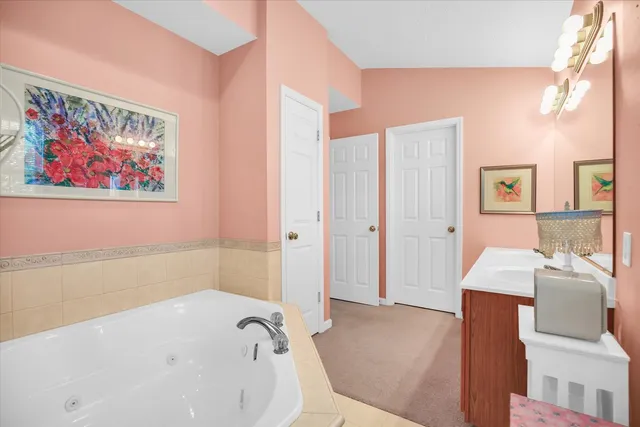 a bathroom with a tub sink and mirror