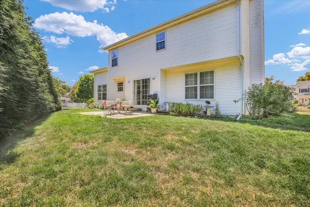a front view of house with yard and trees in the background