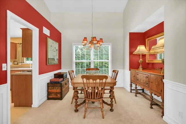 a dining room with furniture and a floor to ceiling window