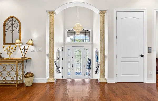 a view of a hallway with wooden floor and front door