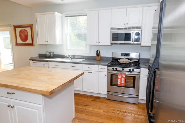 a kitchen with stainless steel appliances granite countertop a stove and a microwave