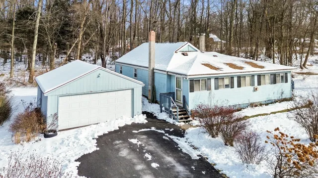 a view of a house with a yard covered with snow