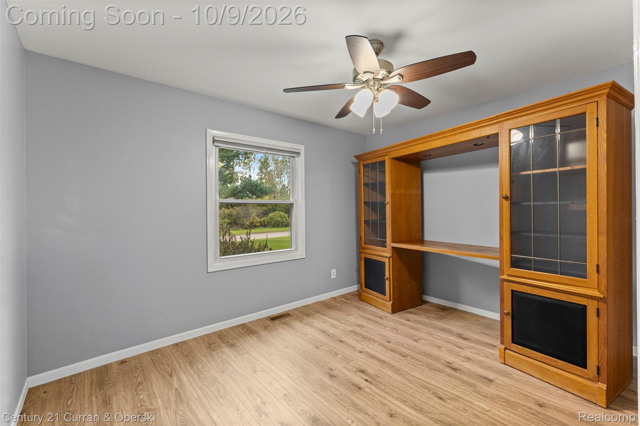 43040 Willis Road Belleville, MI 48111 - Photo 26 of 65 Wood-finish flooring, built-in entertainment center with glass-front cabinetry, ceiling fan with integrated lighting, and a single-pane window