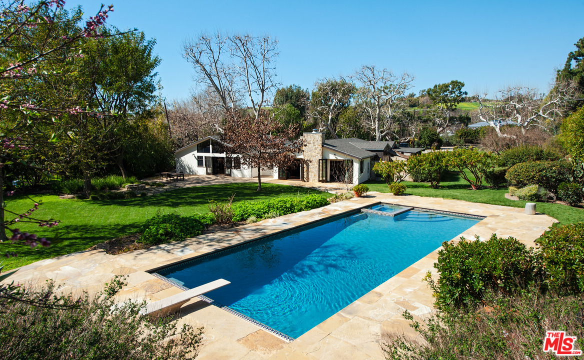 a view of a house with pool and a yard