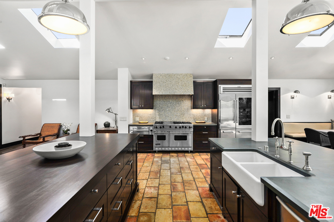 6172 Bonsall Drive Malibu, CA 90265 - Photo 17 of 40 a kitchen with stainless steel appliances a stove a sink a oven and white cabinets