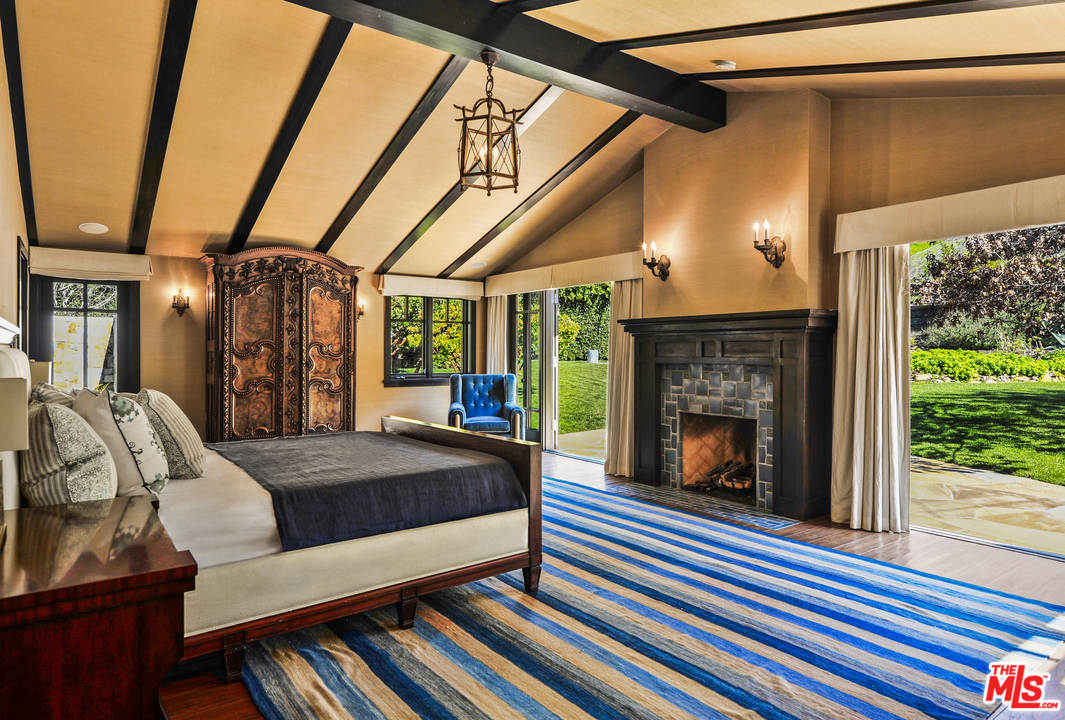 6172 Bonsall Drive Malibu, CA 90265 - Photo 31 of 40 a spacious bedroom with a bed and a fireplace