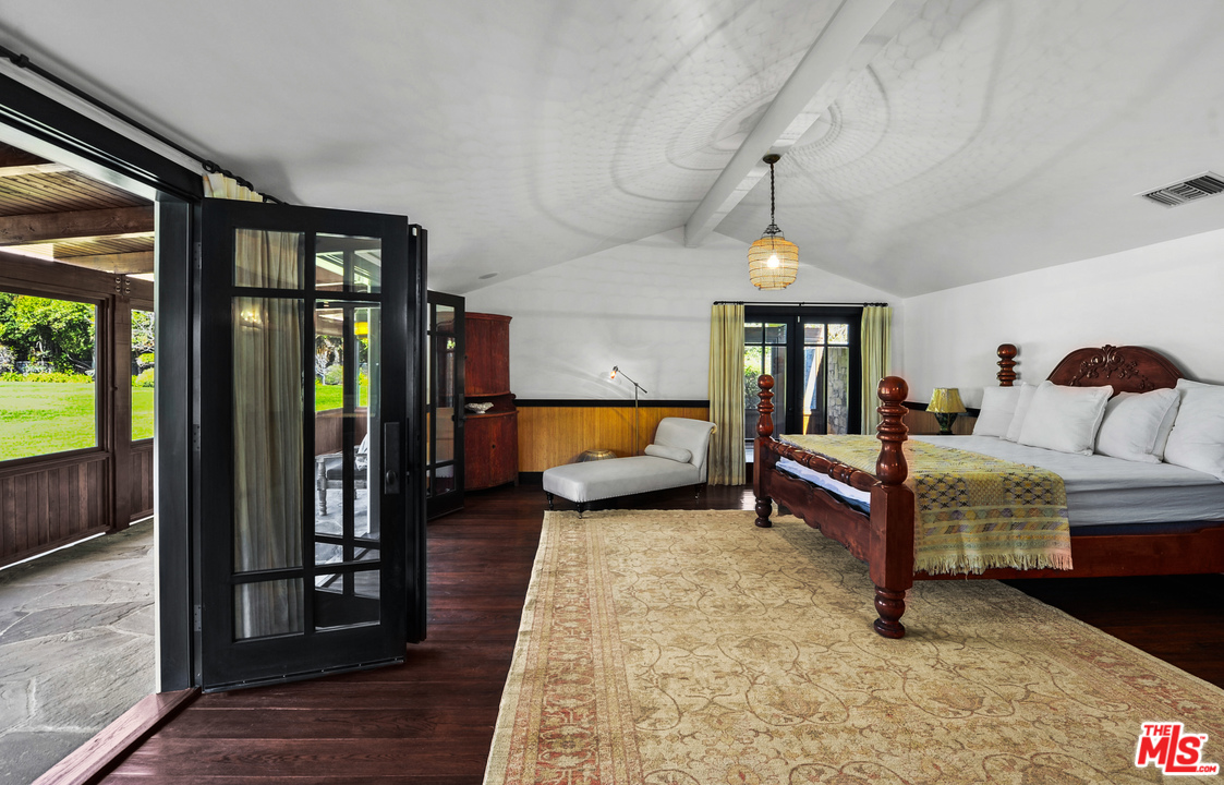 6172 Bonsall Drive Malibu, CA 90265 - Photo 38 of 40 a bedroom with a bed a mirror and a walk in closet