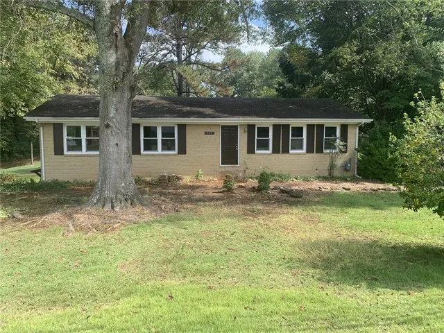 a backyard of a house with yard table and chairs