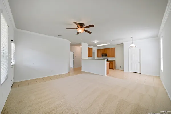 a view of a livingroom with a ceiling fan kitchen view and a window