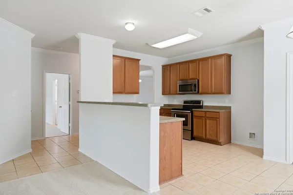 a kitchen with granite countertop a stove top oven a sink dishwasher and a refrigerator