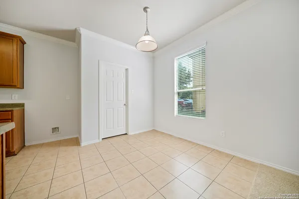 a view of an empty room with window and chandelier fan