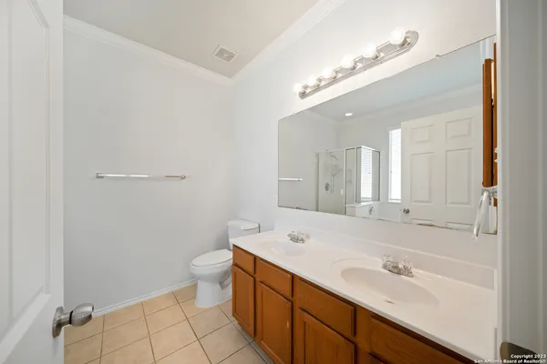 a bathroom with a double vanity sink mirror and toilet