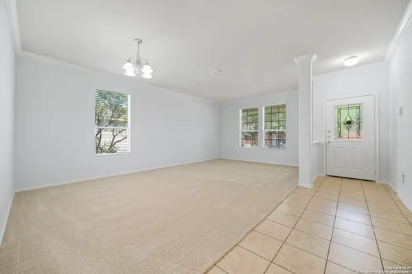 an empty room with windows and ceiling fan