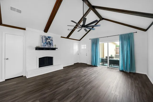 a view of empty room with wooden floor and fireplace