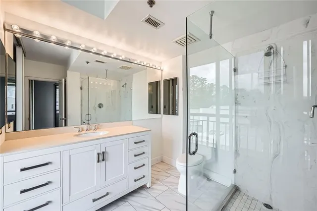 a spacious bathroom with a granite countertop sink mirror and shower