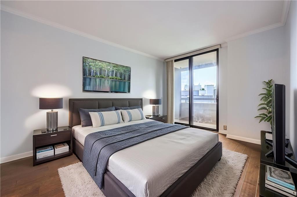 3481 Lakeside Drive Northeast, Unit 1107 Atlanta, GA 30326 - Photo 22 of 35 a spacious bedroom with a bed and a flat screen tv