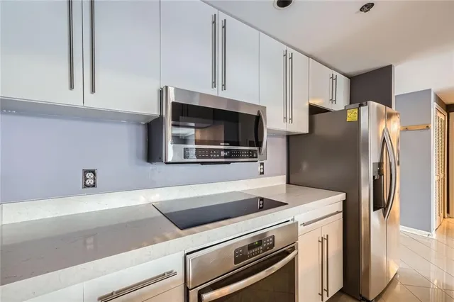 a kitchen with stainless steel appliances a refrigerator microwave and sink