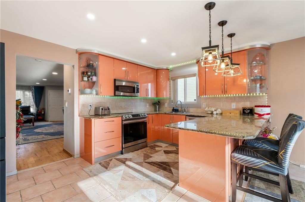 1314 East 69th Street Brooklyn, NY 11234 - Photo 11 of 42 a kitchen with stainless steel appliances granite countertop a sink stove and refrigerator