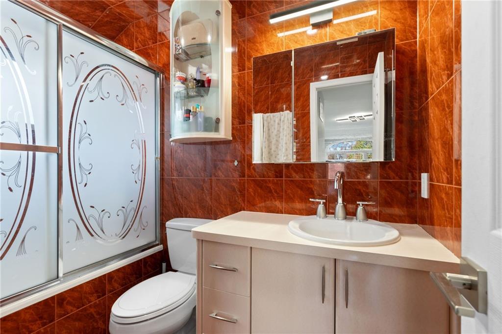 1314 East 69th Street Brooklyn, NY 11234 - Photo 20 of 42 a bathroom with a toilet a sink and a mirror