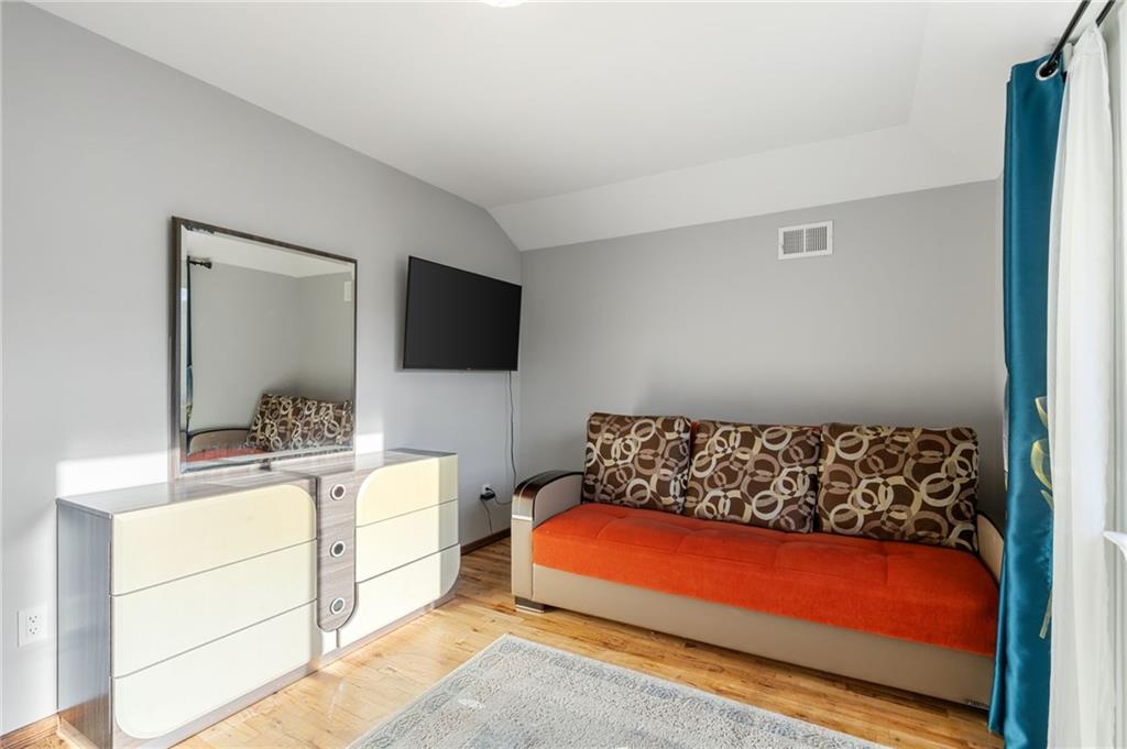 1314 East 69th Street Brooklyn, NY 11234 - Photo 27 of 42 a bedroom with a bed and flat tv screen on the dresser