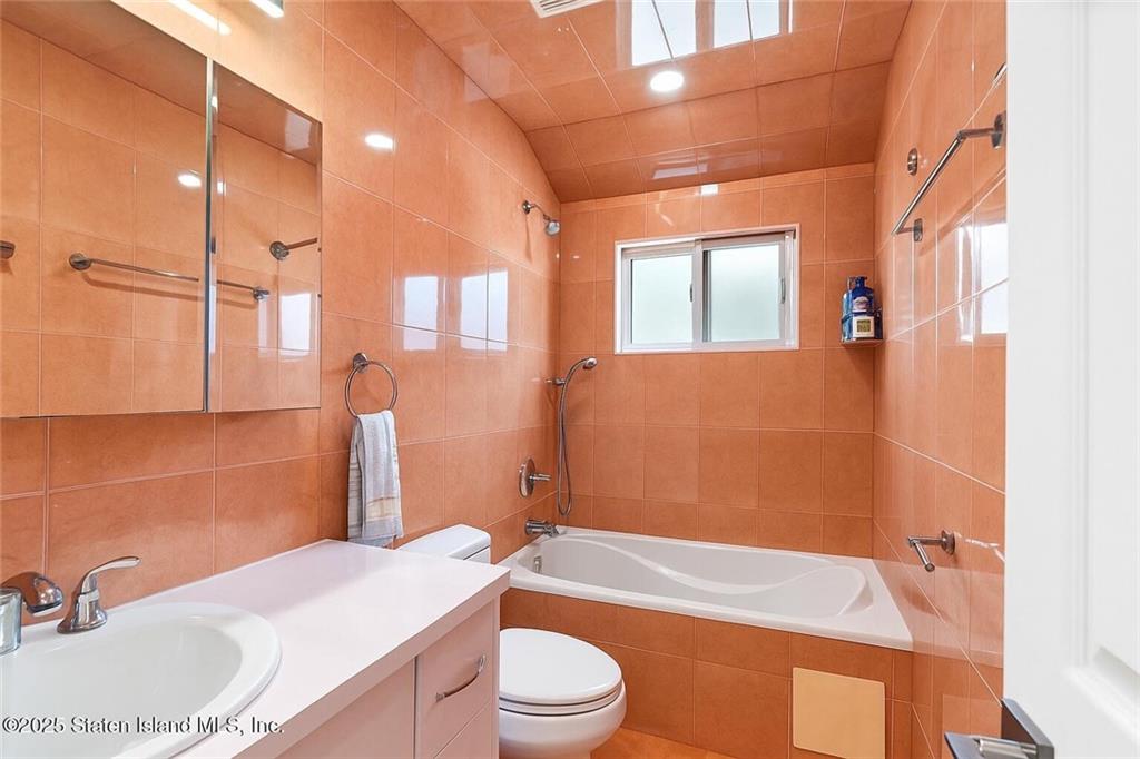 1314 East 69th Street Brooklyn, NY 11234 - Photo 28 of 42 a bathroom with a granite countertop sink toilet and shower