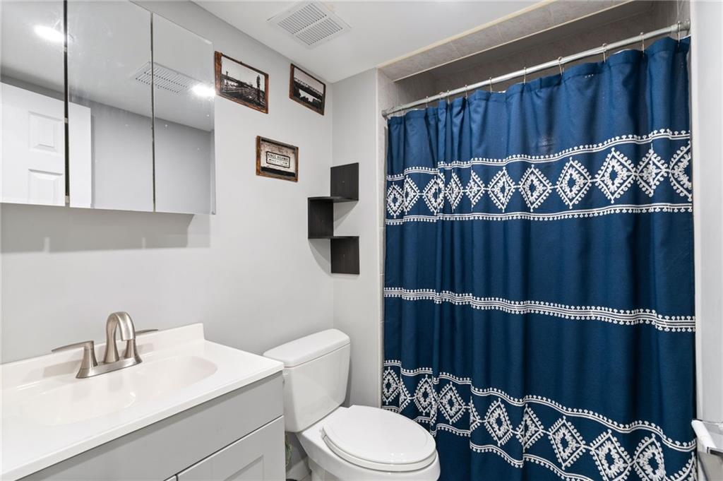 1314 East 69th Street Brooklyn, NY 11234 - Photo 33 of 42 a bathroom with a toilet a sink and mirror