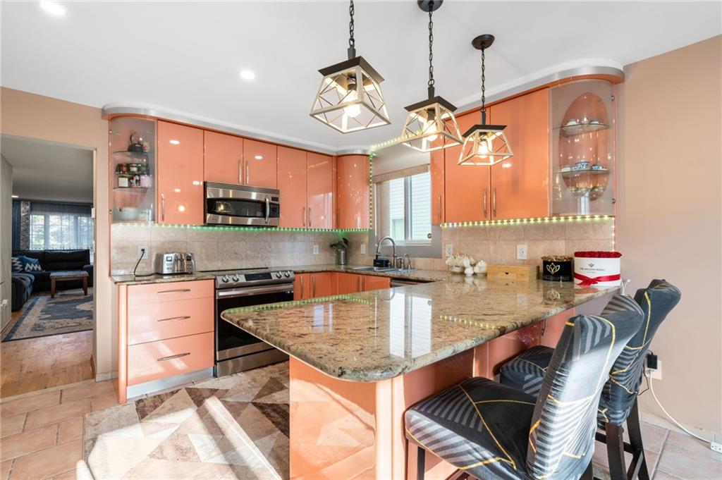 1314 East 69th Street Brooklyn, NY 11234 - Photo 8 of 42 a kitchen with stainless steel appliances granite countertop a kitchen island hardwood floor sink stove dining table and chairs