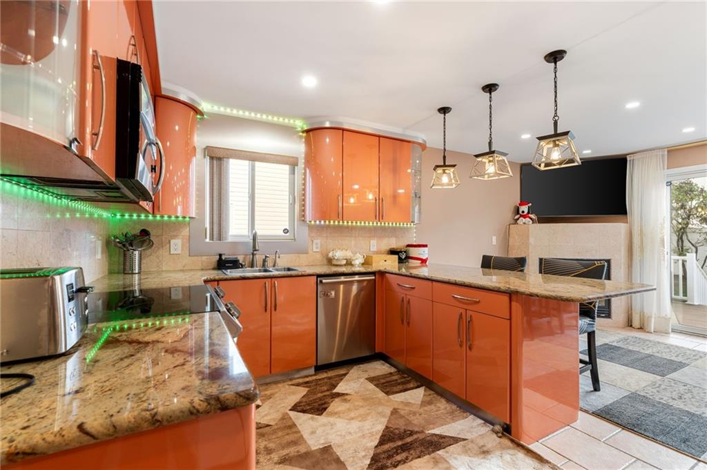 1314 East 69th Street Brooklyn, NY 11234 - Photo 10 of 42 a kitchen with stainless steel appliances kitchen island granite countertop a sink a counter top space and living room view
