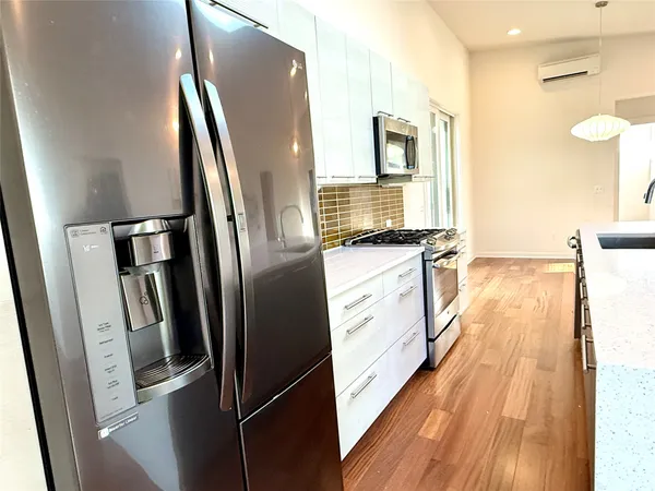a kitchen with stainless steel appliances wooden cabinets a refrigerator and a sink