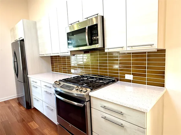 a kitchen with stainless steel appliances granite countertop a refrigerator and a sink
