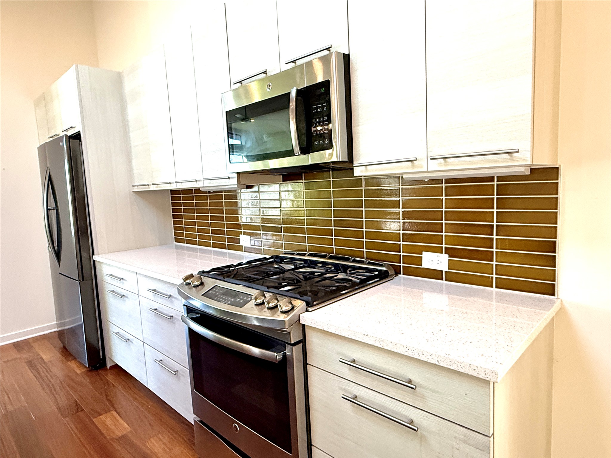 416 Starlight Village Loop Leander, TX 78641 - Photo 13 of 28 Kitchen featuring stainless steel appliances, light stone countertops, decorative backsplash, and modern cabinets