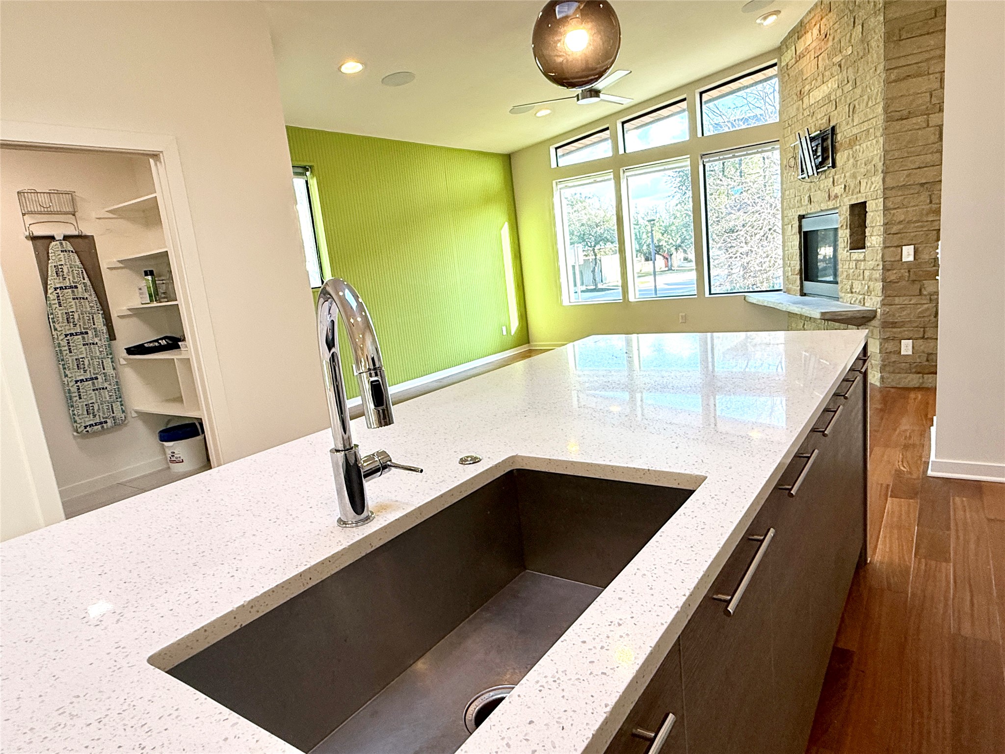 416 Starlight Village Loop Leander, TX 78641 - Photo 14 of 28 Kitchen with light stone countertops, dark wood-style floors, dark wood finish cabinetry, recessed lighting, and a stone fireplace