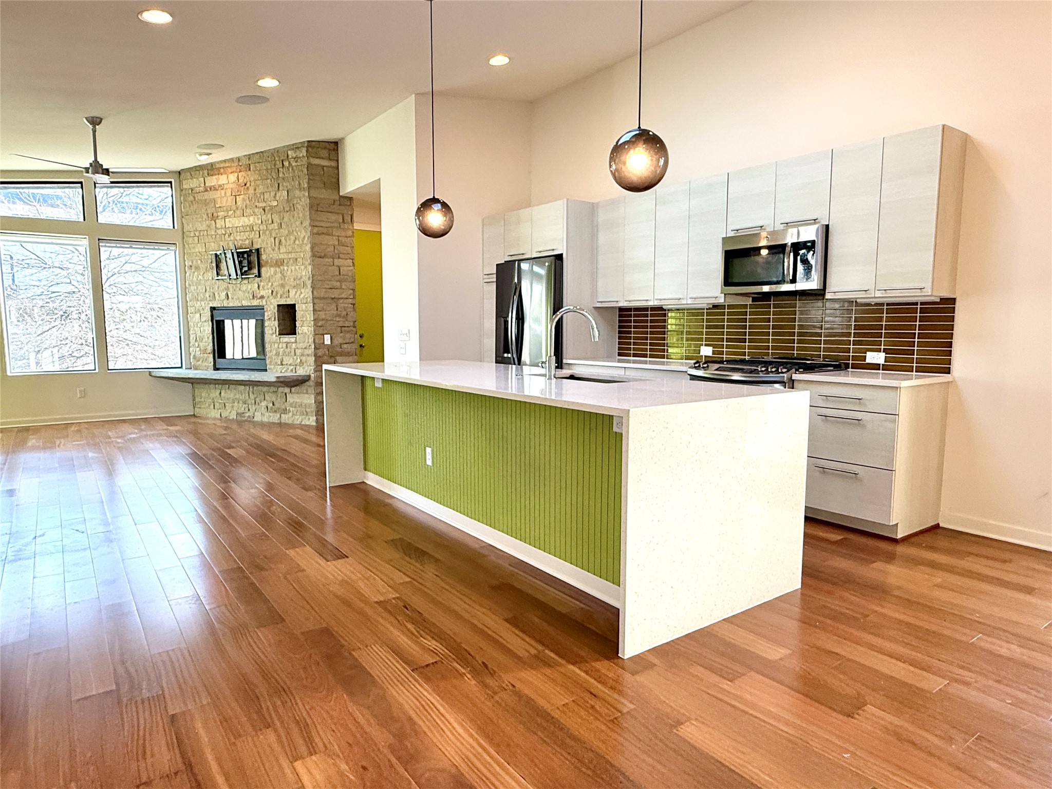 416 Starlight Village Loop Leander, TX 78641 - Photo 28 of 28 Kitchen featuring pendant lighting, stainless steel appliances, light wood-type flooring, vaulted ceiling, and open floor plan