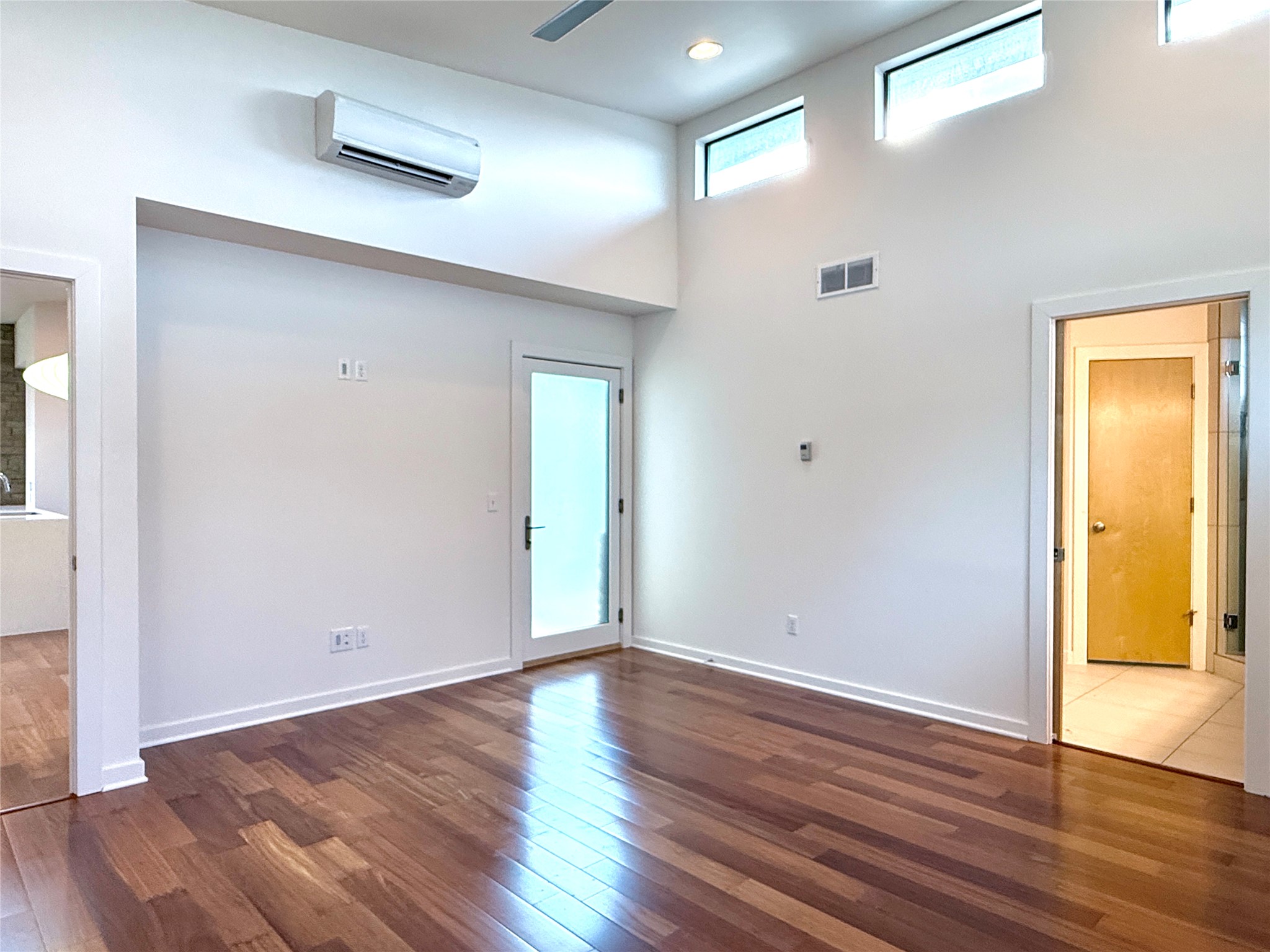 416 Starlight Village Loop Leander, TX 78641 - Photo 20 of 28 Empty room with a high ceiling, a mini split for heating / cooling, and dark wood finished floors