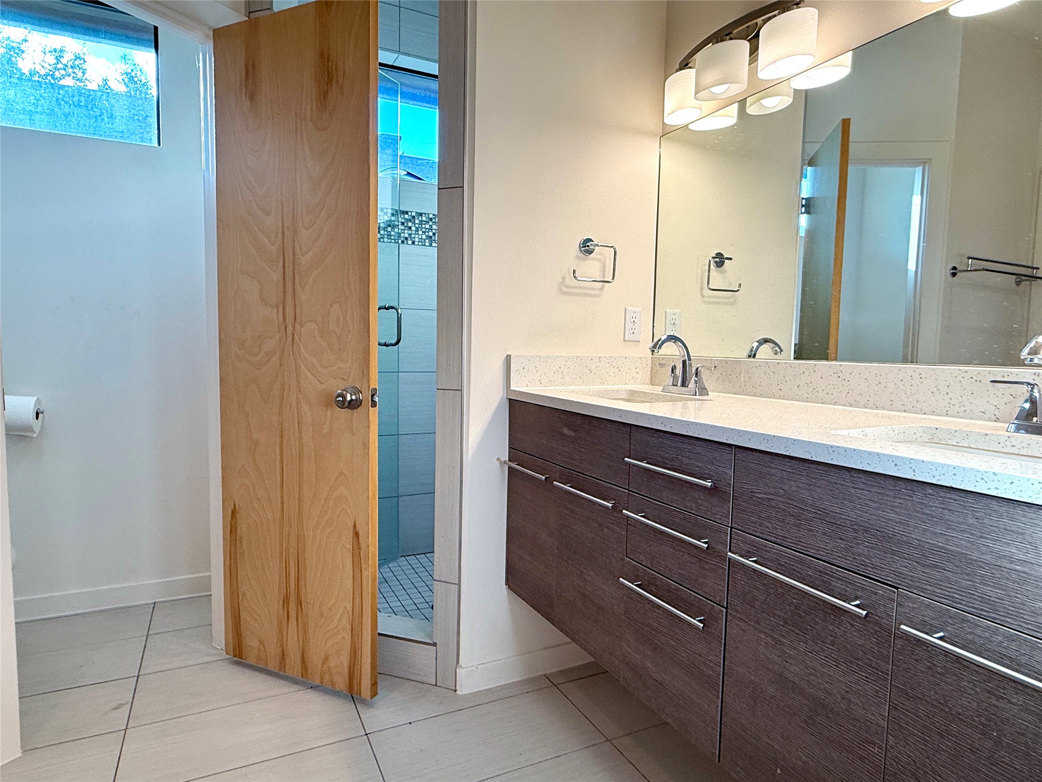 416 Starlight Village Loop Leander, TX 78641 - Photo 25 of 28 Bathroom featuring double vanity, a stall shower, and light tile patterned flooring
