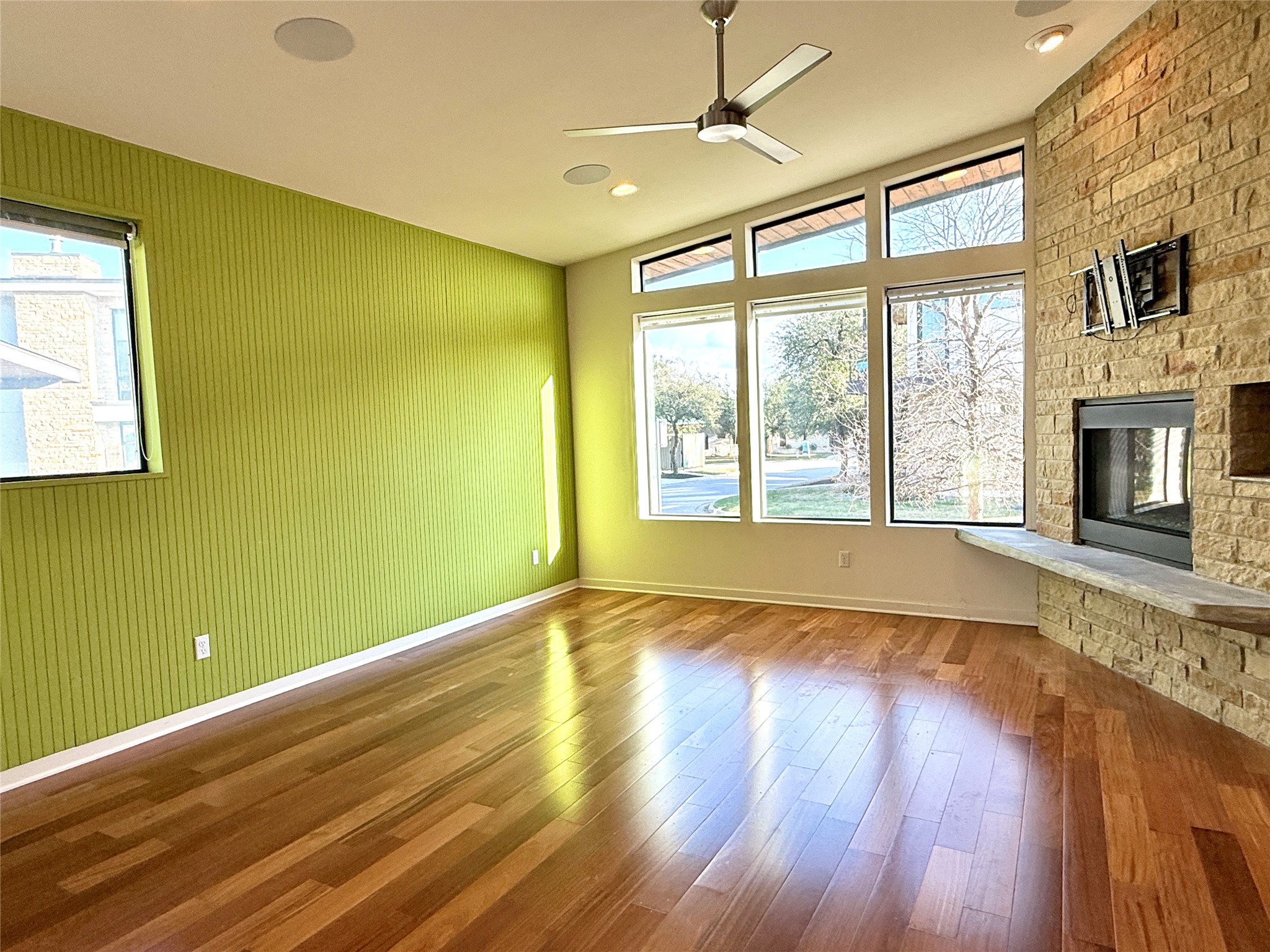 416 Starlight Village Loop Leander, TX 78641 - Photo 26 of 28 Unfurnished living room featuring a fireplace, dark wood-type flooring, a ceiling fan, and recessed lighting