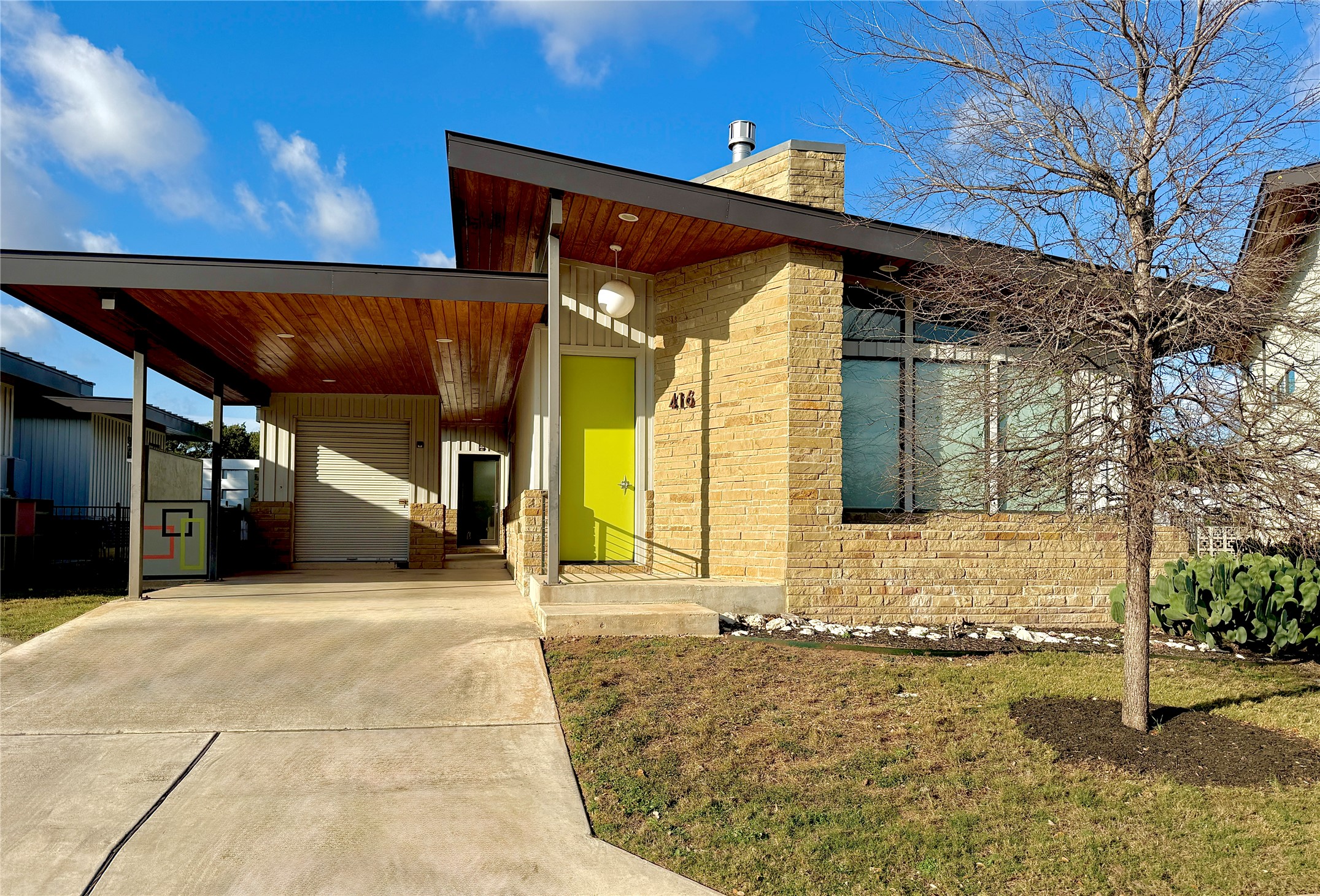 416 Starlight Village Loop Leander, TX 78641 - Photo 6 of 28 View of front facade featuring an attached carport, brick siding, concrete driveway, and a chimney