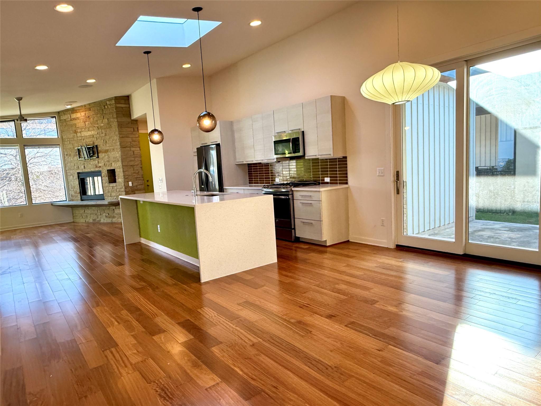 416 Starlight Village Loop Leander, TX 78641 - Photo 27 of 28 Kitchen with open floor plan, a skylight, hanging light fixtures, stainless steel appliances, and dark wood-style flooring