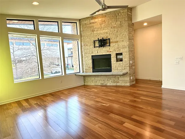 an open kitchen with wooden floor and large windows